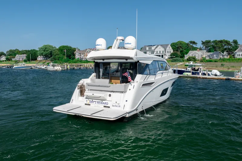 Slide: The Image of 2017 Sea Ray Sundancer 460 yacht cruising near a scenic coastal dock. - 5