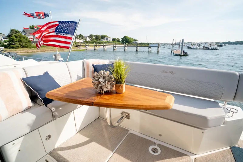 Slide: The Image of 2017 Sea Ray Sundancer 460 yacht deck with seating, table, and American flag. - 27