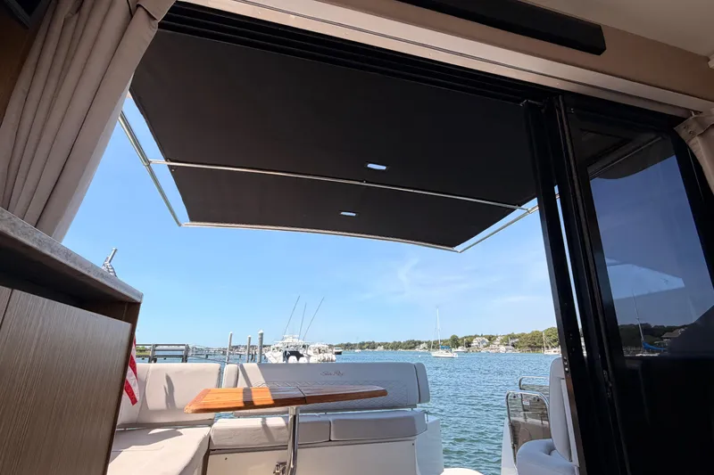 Slide: The Image of 2017 Sea Ray Sundancer 460 yacht interior with open deck view of serene waters. - 15
