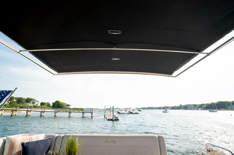 Slide: The Image of 2017 Sea Ray Sundancer 460 yacht with canopy, overlooking a serene marina view. - 29