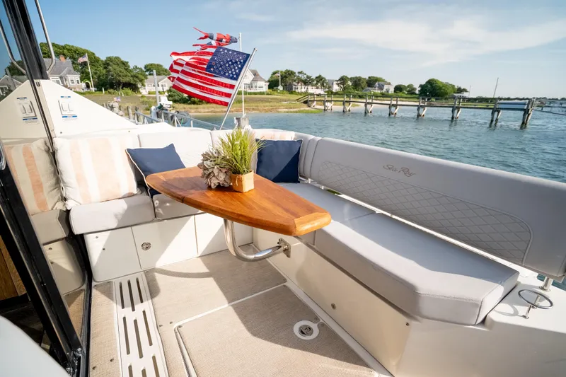 Slide: The Image of 2017 Sea Ray Sundancer 460 yacht deck with seating, table, and American flag. - 28