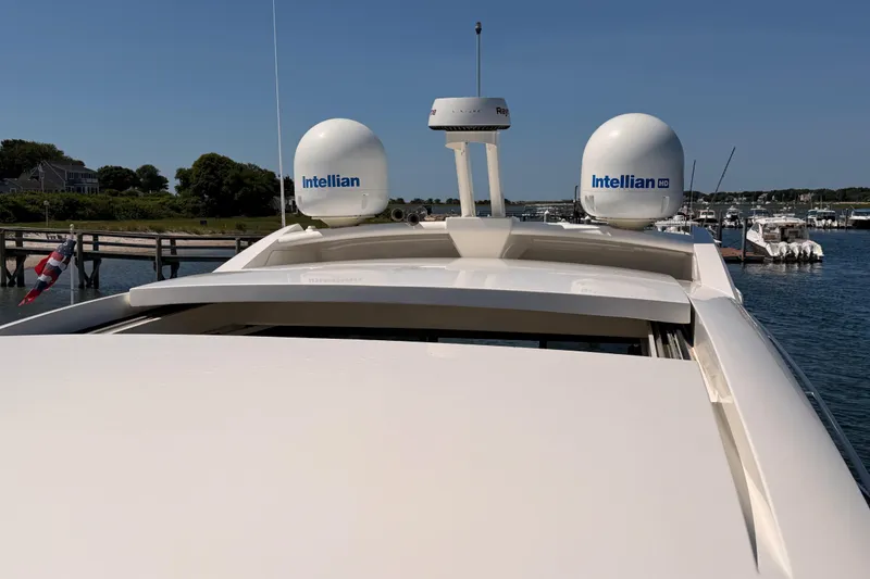 Slide: The Image of 2017 Sea Ray Sundancer 460 yacht with Intellian satellite domes, docked in a scenic marina. - 21
