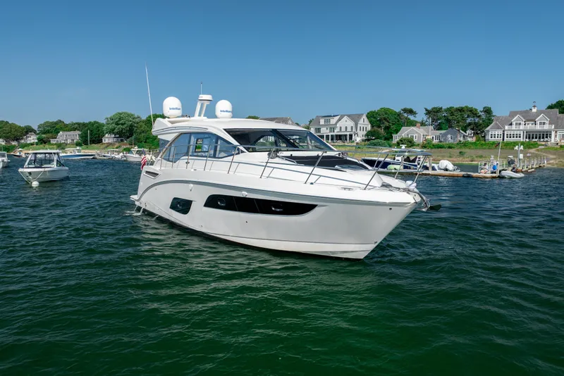 Slide: The Image of 2017 Sea Ray Sundancer 460 yacht cruising near coastal homes on a sunny day. - 9