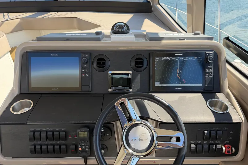 Slide: The Image of Cockpit of 2017 Sea Ray Sundancer 460 with navigation screens and steering wheel. - 23