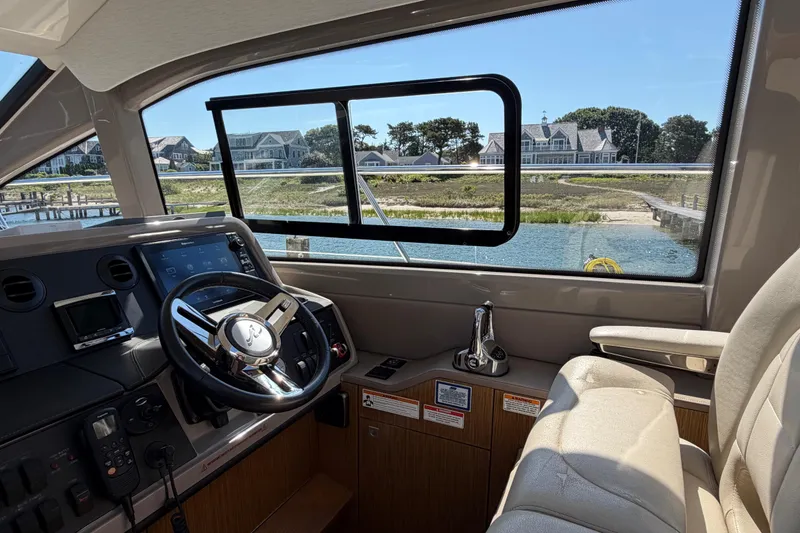 Slide: The Image of Interior view of 2017 Sea Ray Sundancer 460 yacht helm with waterfront scenery. - 22