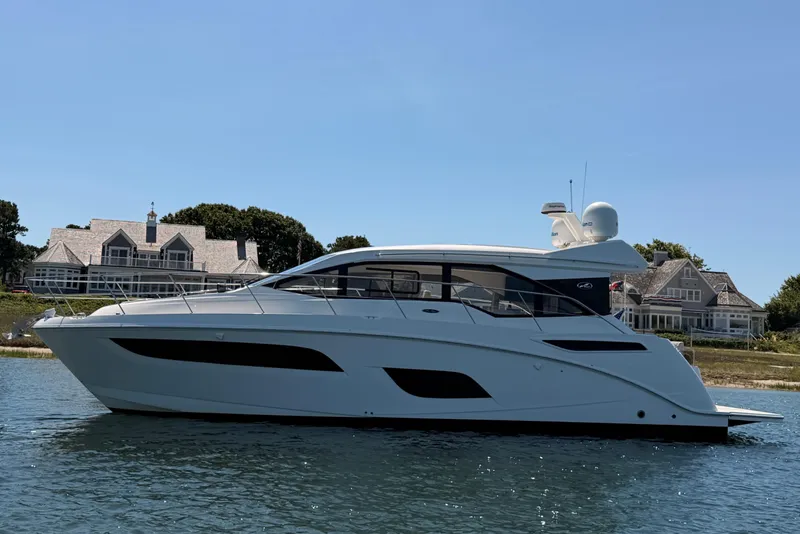 Slide: The Image of 2017 Sea Ray Sundancer 460 yacht on water, with houses in the background. - 1