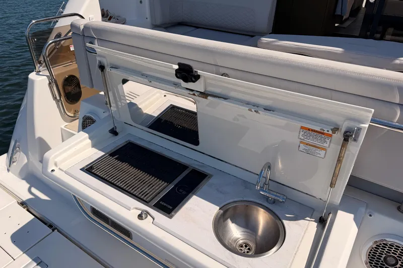 Slide: The Image of 2017 Sea Ray Sundancer 460 yacht with outdoor kitchenette, featuring grill and sink. - 11