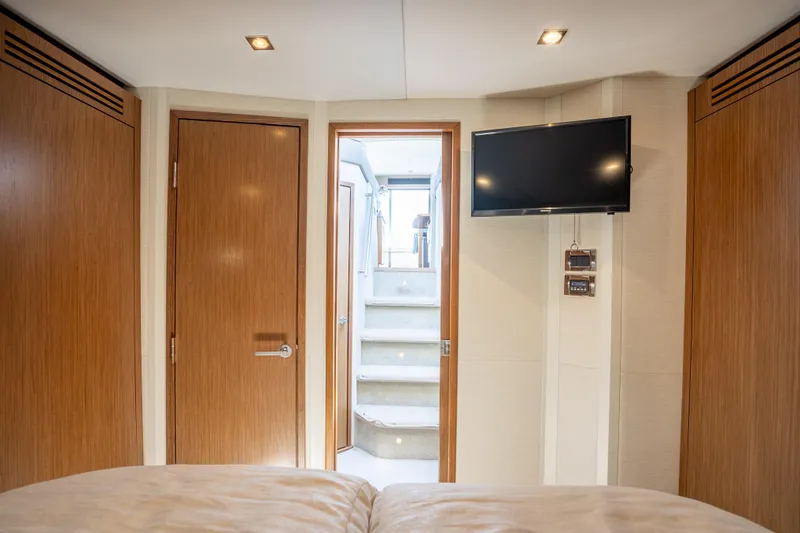 Slide: The Image of Interior of 2017 Sea Ray Sundancer 460 yacht cabin with TV and wooden doors. - 50