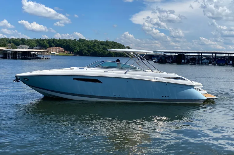 Slide: The Image of 2015 Cobalt 336 boat on a serene lake with blue skies and docks in the background. - 4
