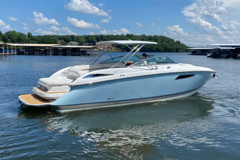 Slide: The Image of 2015 Cobalt 336 boat cruising on a lake under a clear blue sky. - 6