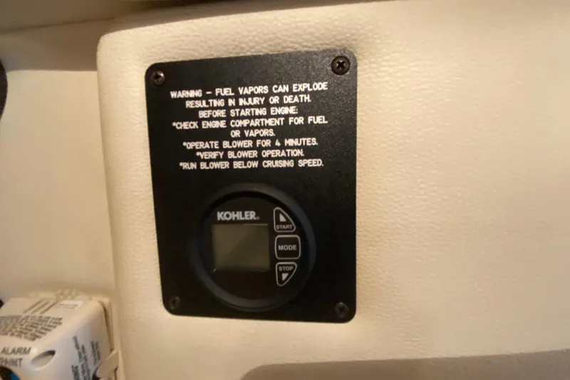 Slide: The Image of Warning label and Kohler control panel on 2015 Cobalt 336 boat interior. - 42