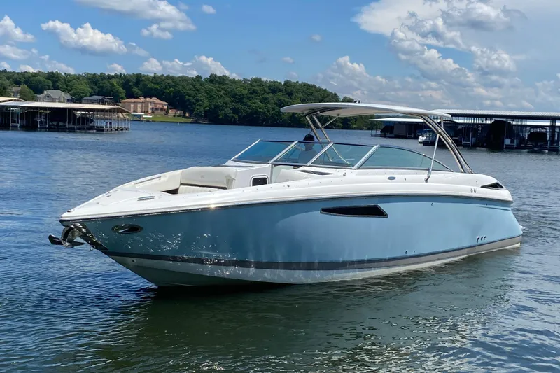 The Image of 2015 Cobalt 336 boat on a serene lake under a clear blue sky. - 0
