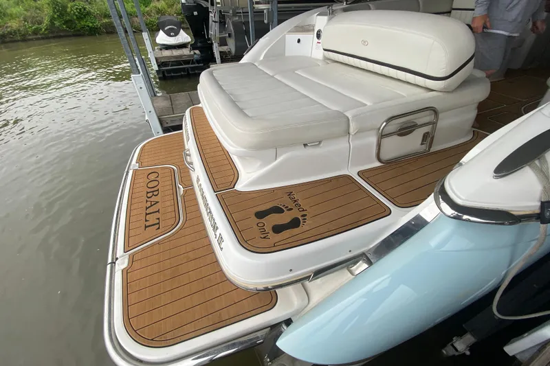 Slide: The Image of 2015 Cobalt 336 boat with teak deck, white seating, docked by water. - 15