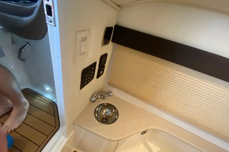 Slide: The Image of Interior of a 2015 Cobalt 336 boat featuring a compact sink and control panel. - 47