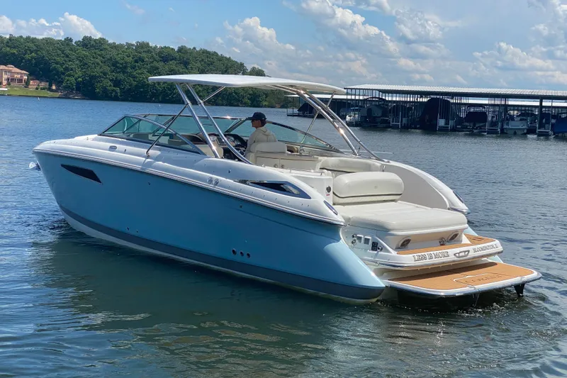 Slide: The Image of 2015 Cobalt 336 boat cruising on a lake under a clear blue sky. - 7