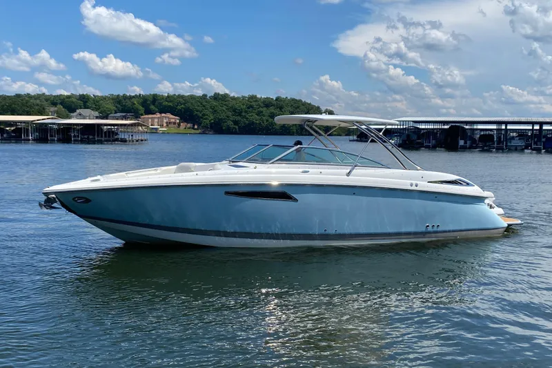 Slide: The Image of 2015 Cobalt 336 boat on a serene lake with blue skies and docks in the background. - 3