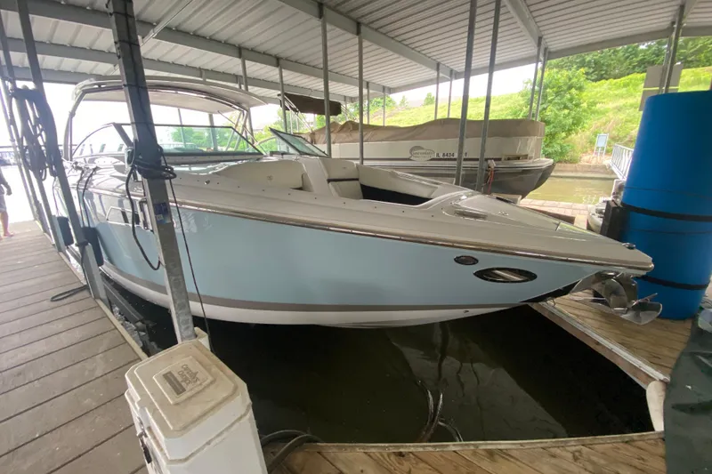 Slide: The Image of 2015 Cobalt 336 boat docked under a covered marina, showcasing sleek design and luxury features. - 12
