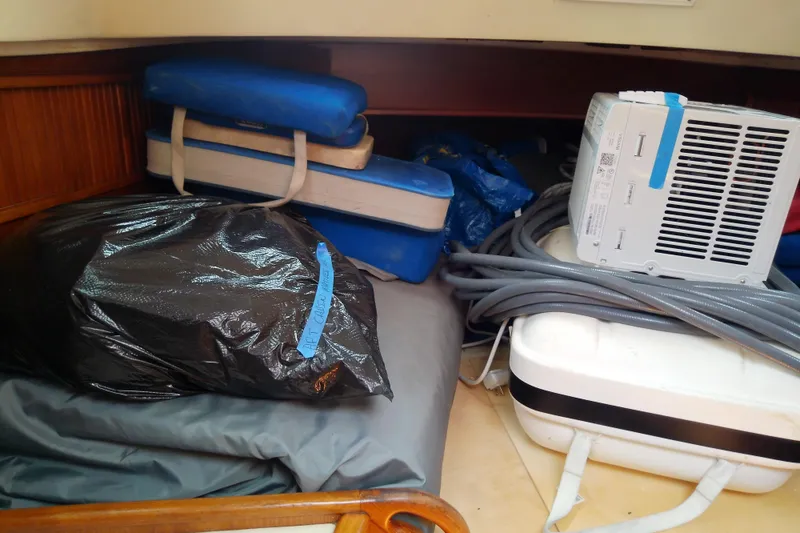 Slide: The Image of Storage area in a 1988 Brewer 44 boat with cushions, cables, and equipment. - 78