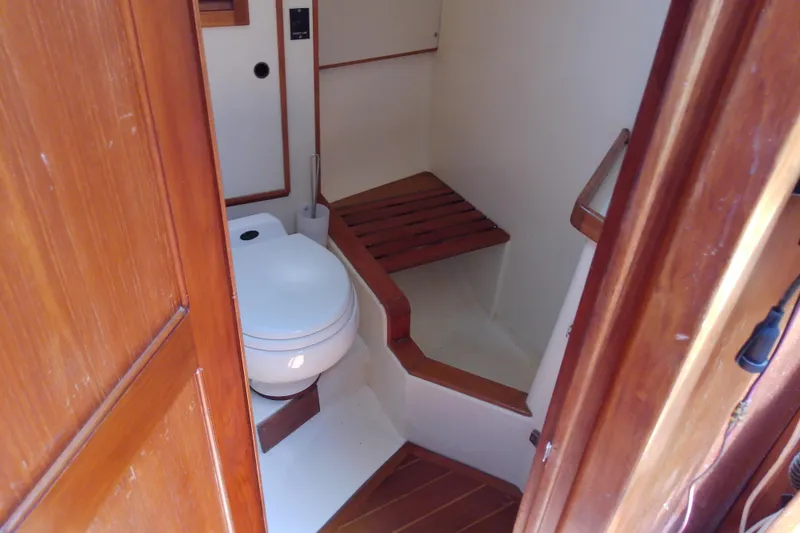 Slide: The Image of 1988 Brewer 44 yacht bathroom with wooden accents and compact toilet. - 86