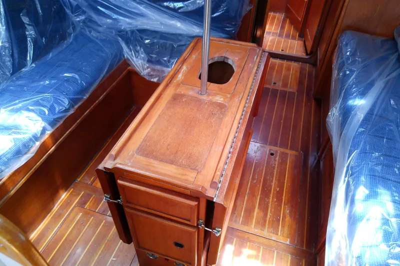 Slide: The Image of Interior of a 1988 Brewer 44 sailboat with wooden flooring and blue cushioned seating. - 44