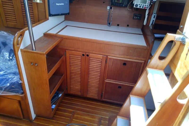 Slide: The Image of Interior of a 1988 Brewer 44 sailboat featuring wooden cabinetry and navigation equipment. - 55