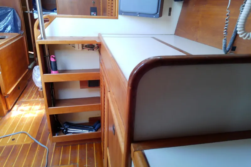Slide: The Image of Interior of a 1988 Brewer 44 sailboat with wooden cabinetry and shelving. - 63