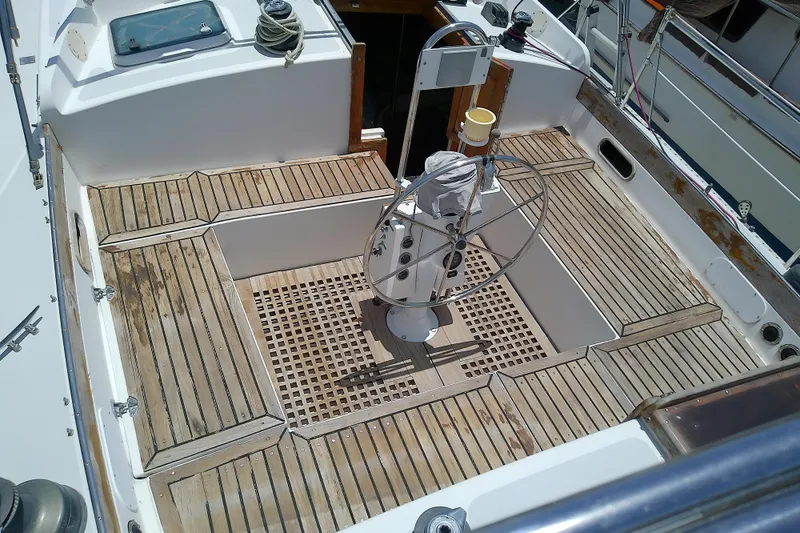 Slide: The Image of Cockpit of a 1988 Brewer 44 sailboat with wooden flooring and steering wheel. - 26