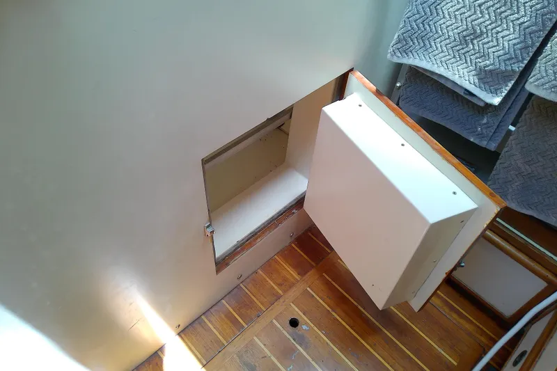 Slide: The Image of Hidden compartment in 1988 Brewer 44 boat interior with wooden flooring and towels. - 53