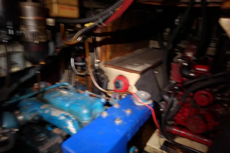 Slide: The Image of Engine room of a 1988 Brewer 44 boat, featuring various mechanical components and wiring. - 75
