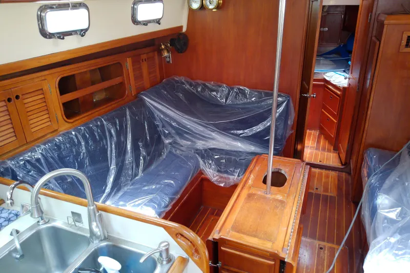Slide: The Image of Interior of a 1988 Brewer 44 sailboat with wooden furnishings and covered seating area. - 42