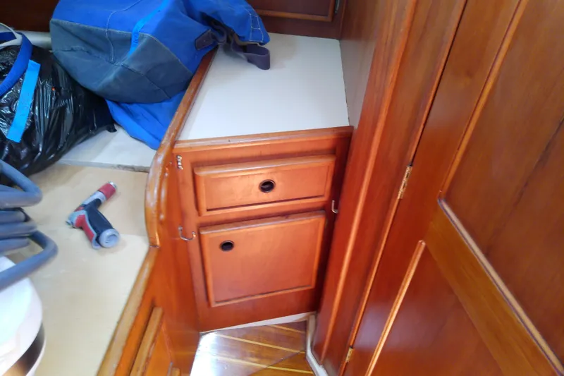 Slide: The Image of Wooden interior of 1988 Brewer 44 boat with storage cabinets and blue bag. - 80