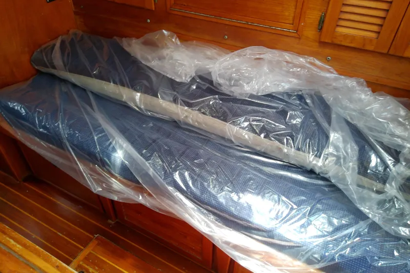 Slide: The Image of Plastic-wrapped cushions on wooden bench inside 1988 Brewer 44 boat cabin. - 65