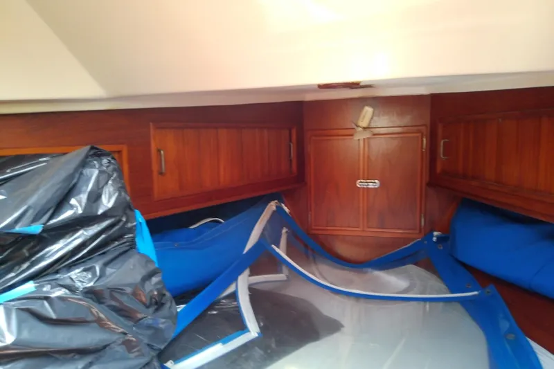 Slide: The Image of Interior of 1988 Brewer 44 sailboat with wooden cabinets and blue tarps. - 67