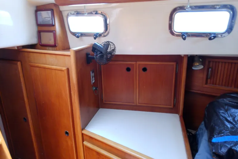 Slide: The Image of Interior of a 1988 Brewer 44 sailboat with wooden cabinetry and a small fan. - 83