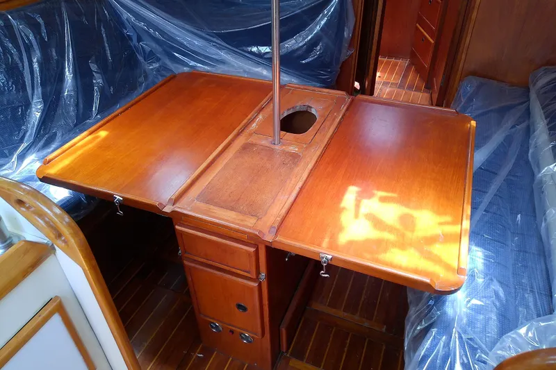 Slide: The Image of Wooden interior of 1988 Brewer 44 sailboat with foldable table and storage. - 45
