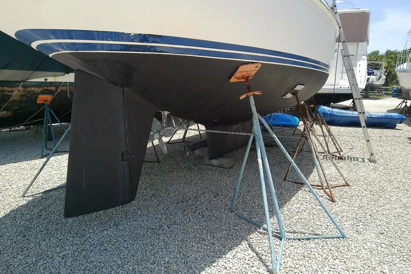 Slide: The Image of 1988 Brewer 44 sailboat on stands, showing keel and propeller in a boatyard. - 9