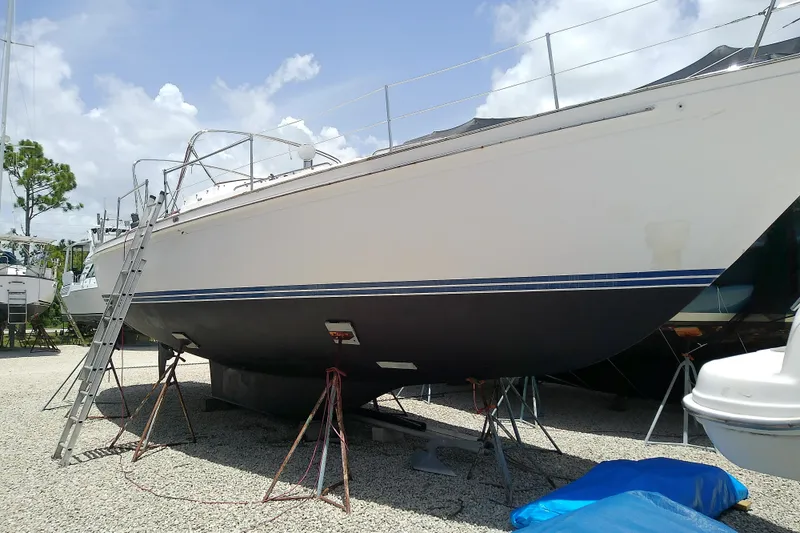Slide: The Image of 1988 Brewer 44 sailboat on stands, ladder leaning, clear sky background. - 14