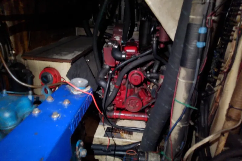 Slide: The Image of Engine room of a 1988 Brewer 44 boat, featuring red and blue machinery components. - 76