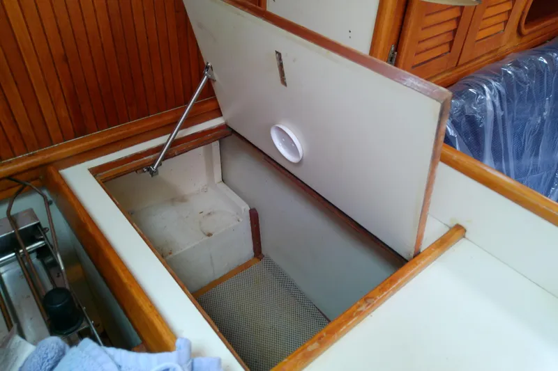 Slide: The Image of Open storage compartment on 1988 Brewer 44 yacht, featuring wooden interior and secure latch. - 54