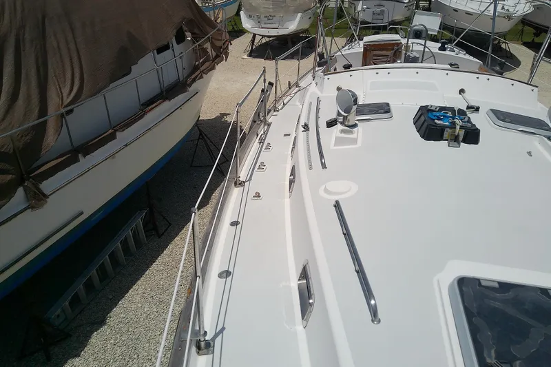 Slide: The Image of 1988 Brewer 44 sailboat on dry dock, surrounded by other vessels. - 21