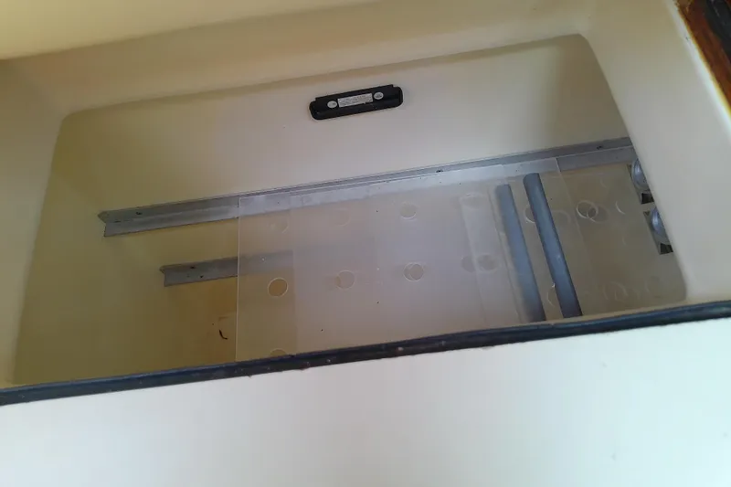 Slide: The Image of Interior compartment of a 1988 Brewer 44 boat, featuring storage space and metal rails. - 52