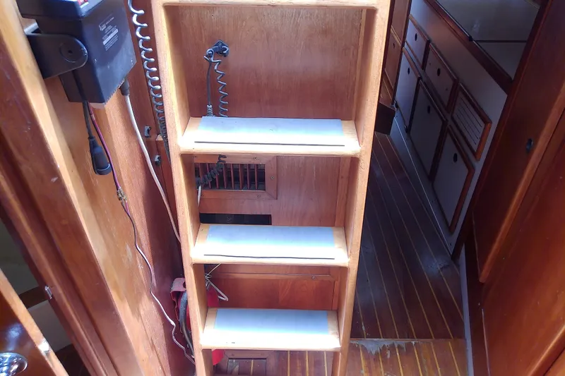Slide: The Image of Wooden interior stairs on a 1988 Brewer 44 boat, featuring a compact design. - 84