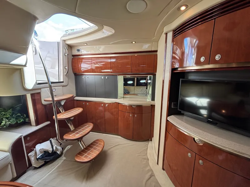 Slide: The Image of Interior of a 2003 Sea Ray 500 Sundancer with elegant wood cabinetry and a flat-screen TV. - 16