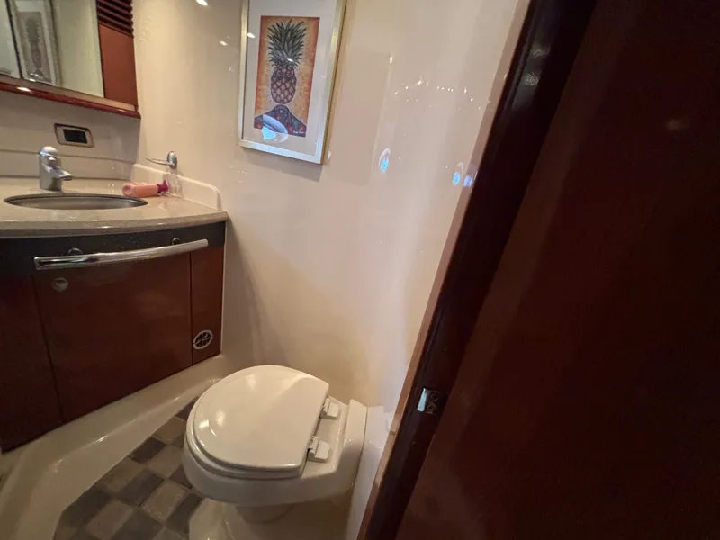 Slide: The Image of The image shows a boat bathroom with a toilet, sink, and a framed picture on the wall. - 22