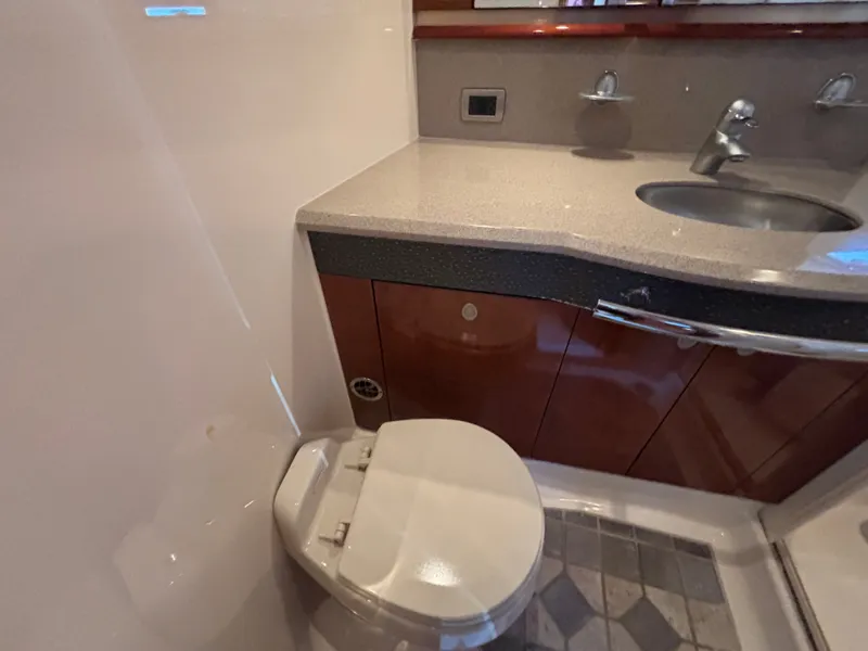 Slide: The Image of The image shows a boat bathroom with a toilet, sink, and mirror. - 25
