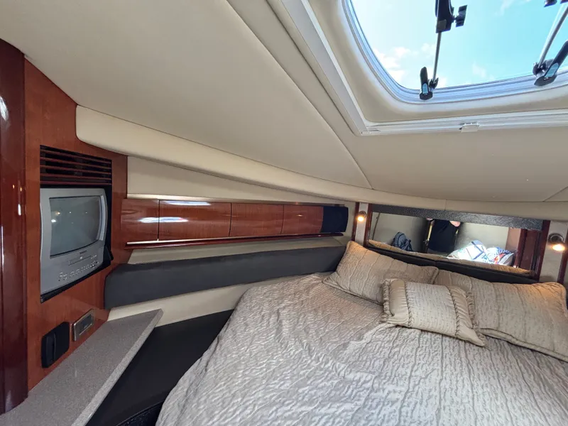 Slide: The Image of The 2003 Sea Ray 500 Sundancer cabin features a cozy bed and a skylight. - 24