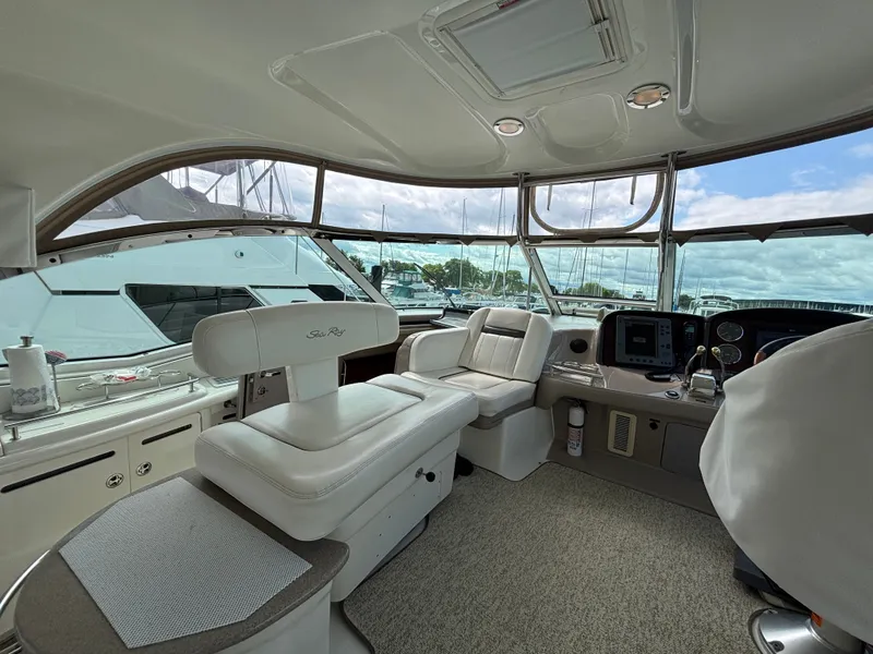 Slide: The Image of Interior of a 2003 Sea Ray 500 Sundancer with elegant white seating and modern electronics. - 8