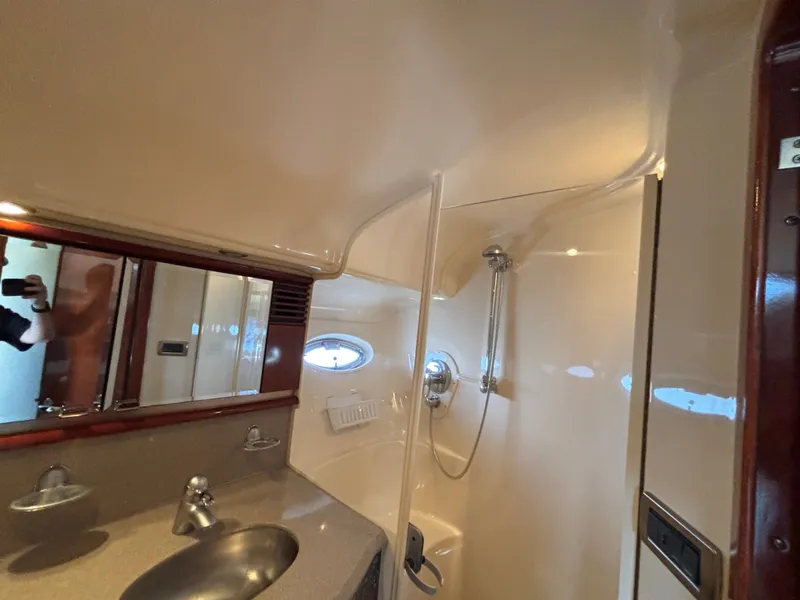 Slide: The Image of The image shows a boat bathroom with a sink, mirror, and shower. - 26