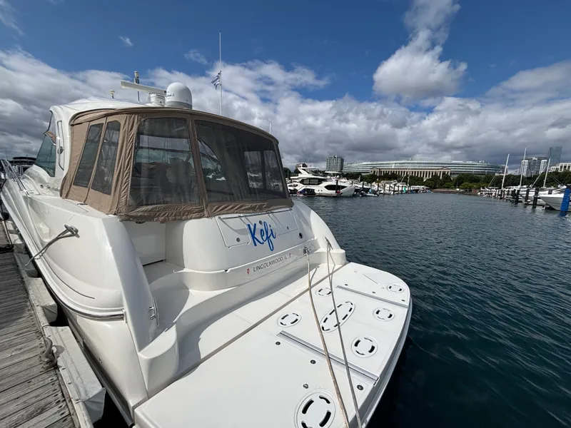 Slide: The Image of A 2003 Sea Ray 500 Sundancer docked at a marina. The sky is partly cloudy. - 3