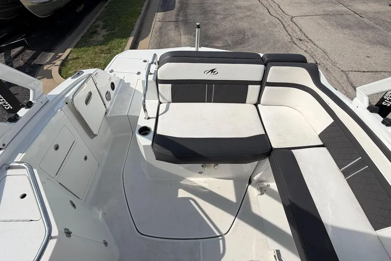 Slide: The Image of 2022 Monterey M4 boat interior with white and black seating, docked on pavement. - 33